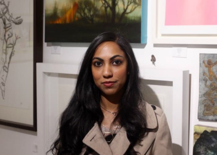 Young curator Shenaz Mahomed standing in front of the ‘Young Collectors’ exhibition.