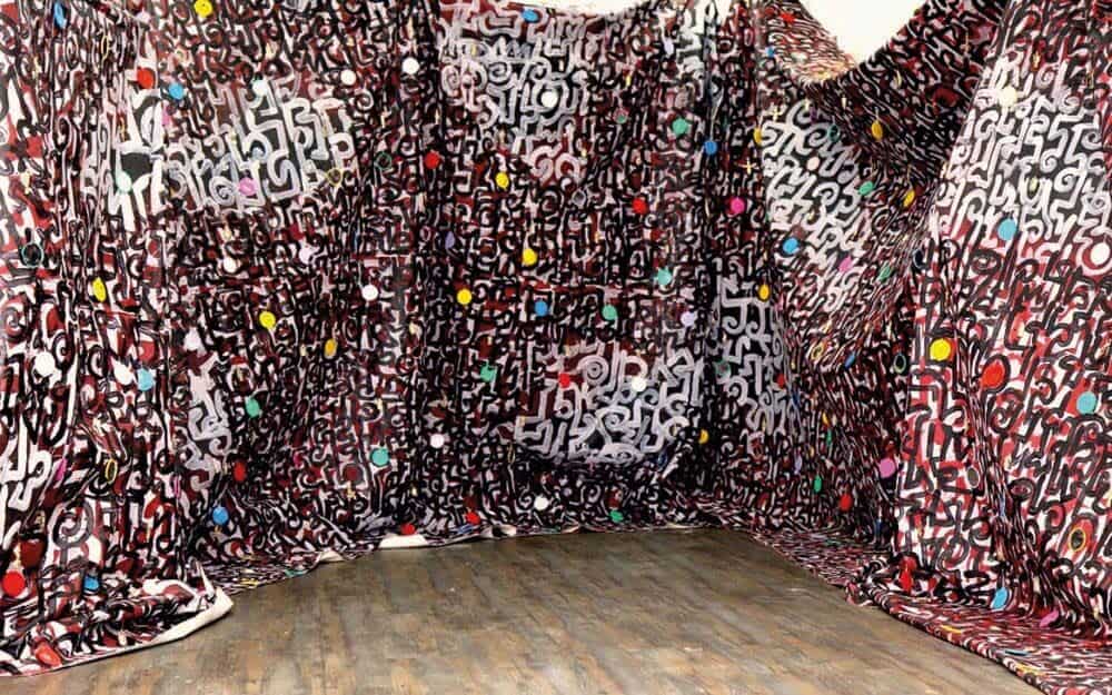Victor Ehikhamenor, Biography of the Forgotten, 2017. Canvas, acrylic paint, mirrors, miniature Benin bronze sculptures, 7 canvases, each: 8.9 x 4.1 m. Courtesy of the artist & Tyburn Gallery.