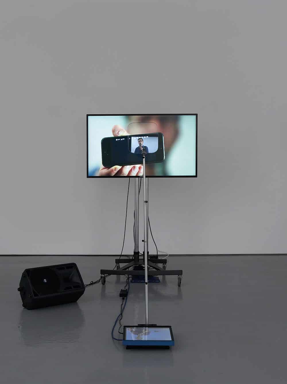 Lawrence Abu Hamdan, Contra Diction (speech against itself), 2015. Two channel video installation, teleprompter, screen, speaker variable dimensions. © Lawrence Abu Hamdan, courtesy Maureen Paley, London.
