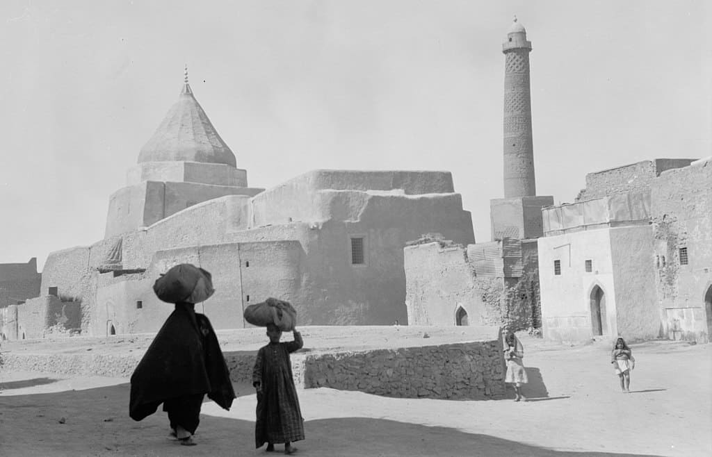 Iraq. Mosul. In the heart of ancient Mosul, showing a Yezidi shrine to the left and the Nouri Mosque minaret to the right. 1932. Courtesy of Wikimedia Commons.