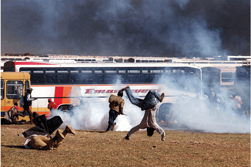 Somersault, Soweto, 1993. African National Congress and Communist Party supporters scatter as police fire teargas and live rounds outside the Soweto soccer stadium where the funeral of ANC and CP leader Chris Hani was attended by hundreds of thousands of mourners on 19 April.